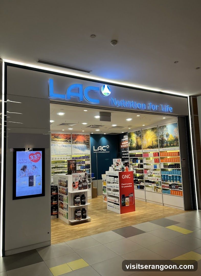 A brightly lit storefront for a store named 'LAC' with the tagline 'Nutrition for Life'. The entrance is open, revealing shelves stocked with various health products, promotional displays, and a digital advertising screen on the left pillar.
