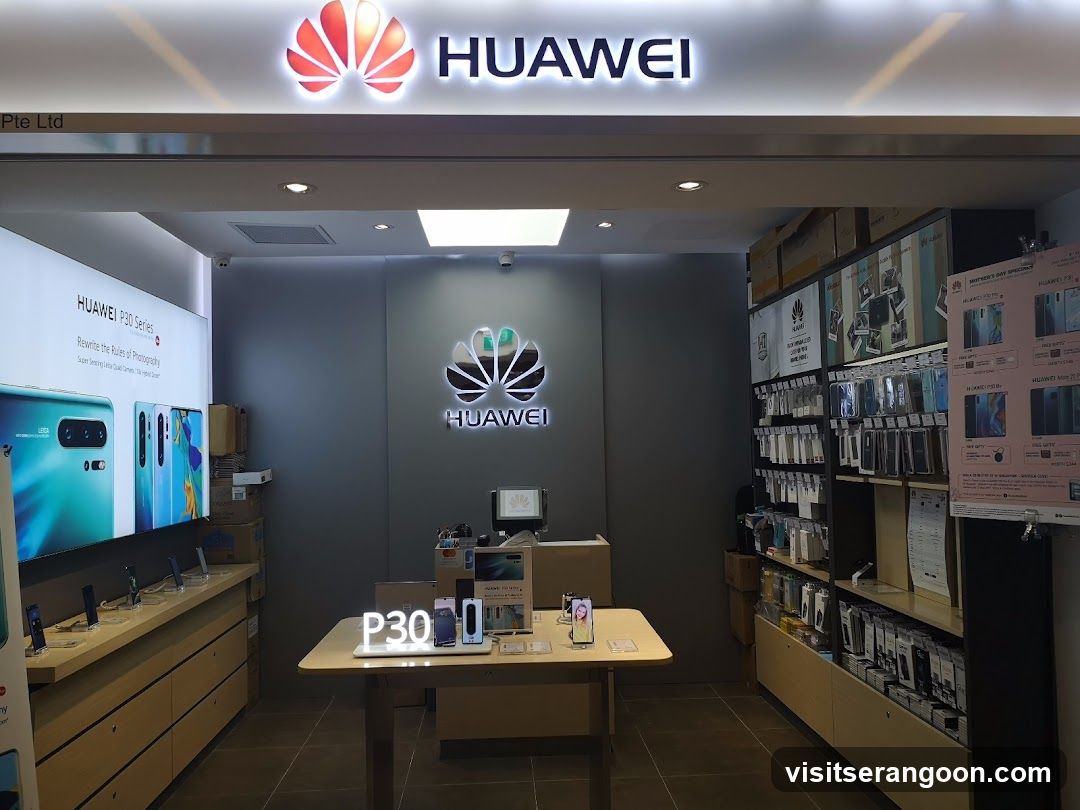 A brightly lit retail store entrance featuring a large, illuminated 'HUAWEI' sign above the doorway. The interior displays various electronic devices, including smartphones on tables and wall-mounted screens advertising the P30 Series. Shelves on the right are stocked with boxed accessories and merchandise.