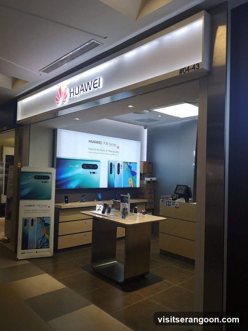 A brightly lit storefront for a Huawei electronics store, featuring a large illuminated sign with the brand name and logo above the entrance. The store number #04-43 is visible on the facade. Inside, a large digital display advertises the P30 Series, and product demonstration tables are arranged on the tiled floor.