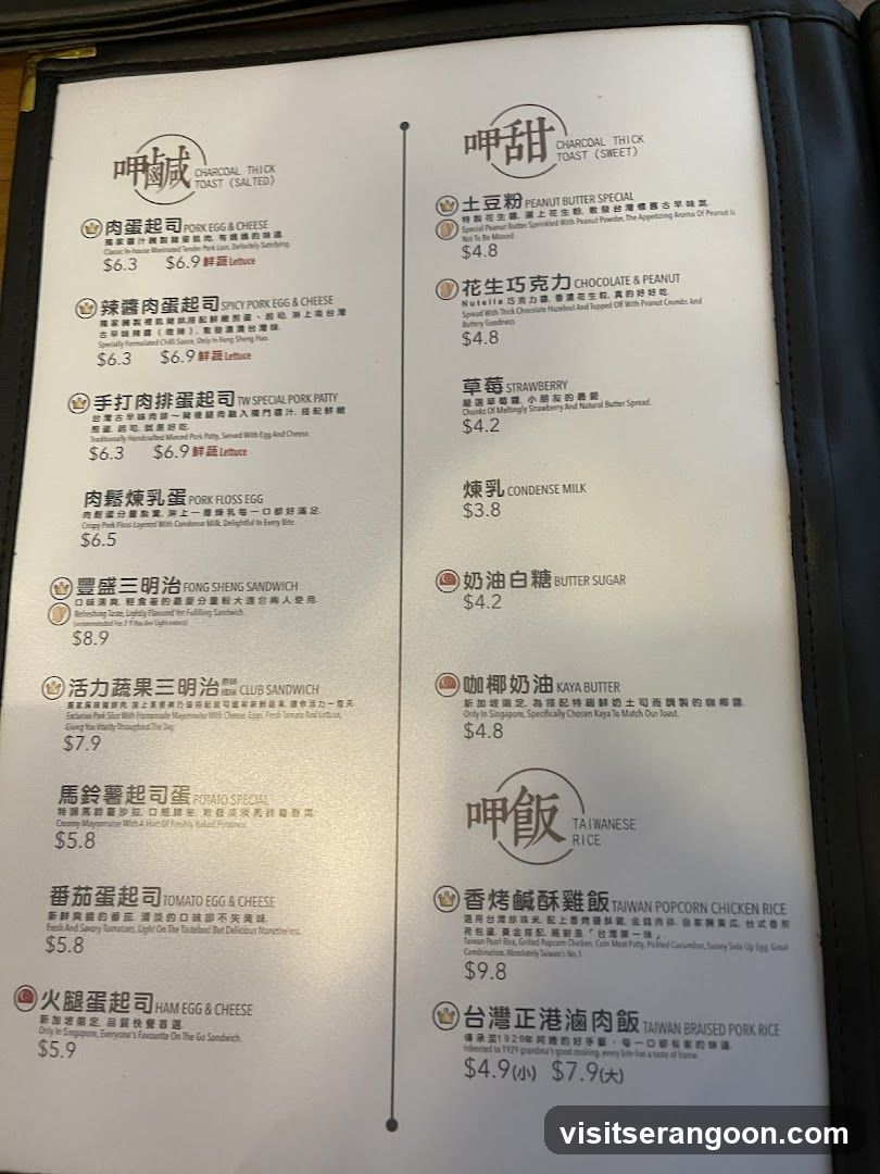 A laminated menu board with two columns of food items, featuring Chinese characters and English translations. The left column includes items like Pork Egg & Cheese, Spicy Pork Egg & Cheese, and Fong Sheng Sandwich. The right column includes Peanut Butter Special, Chocolate & Peanut, and Taiwan Popcorn Chicken Rice.