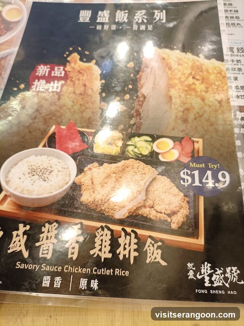 A close-up photograph of a printed menu page advertising a new dish. The image features a large breaded chicken cutlet served on a wooden tray with a bowl of rice, pickled vegetables, and sliced egg. Text includes Chinese characters for 'New Arrival' and 'Feng Sheng Hao', along with the English name 'Savory Sauce Chicken Cutlet Rice' and a price of $14.9.