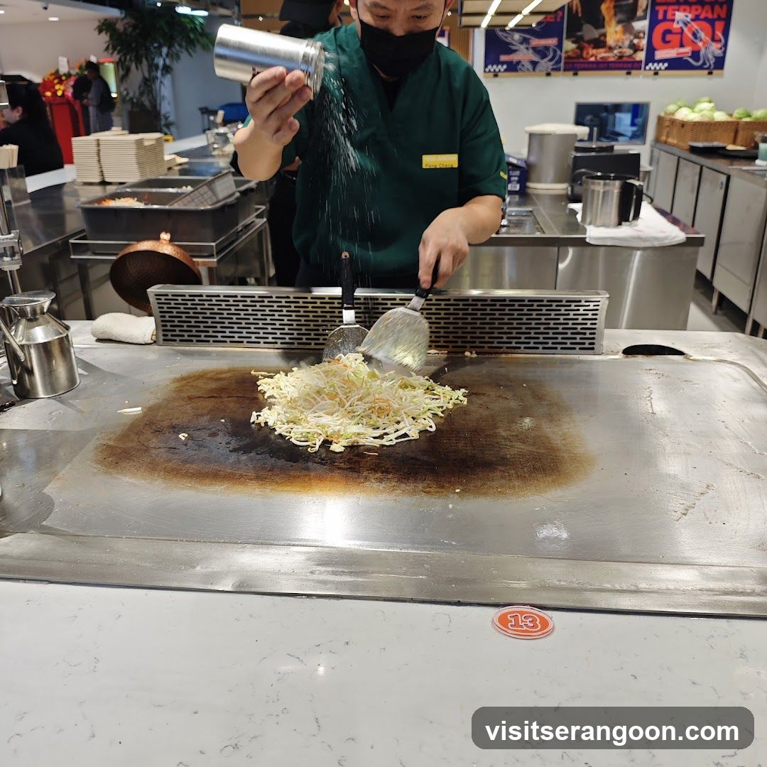 Chef cooking vegetables on a teppanyaki grill
