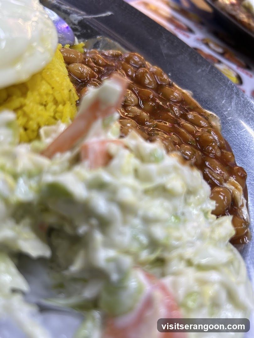 Close-up of a meal with rice, beans, and coleslaw