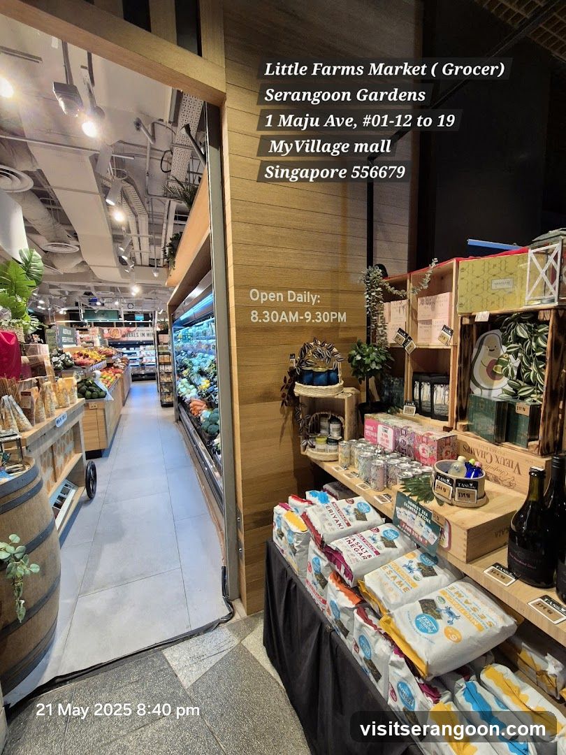 The entrance to Little Farms Market, a grocer, located at 1 Maju Ave, #01-12 to 19, MyVillage mall, Singapore 556679. The store is open daily from 8:30 AM to 9:30 PM. The interior of the market is visible, showing aisles stocked with produce and packaged goods.