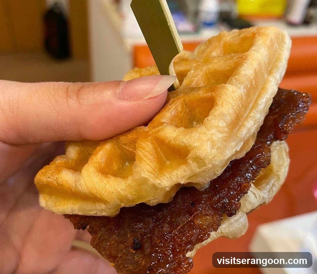 Hand holding waffle sandwich
