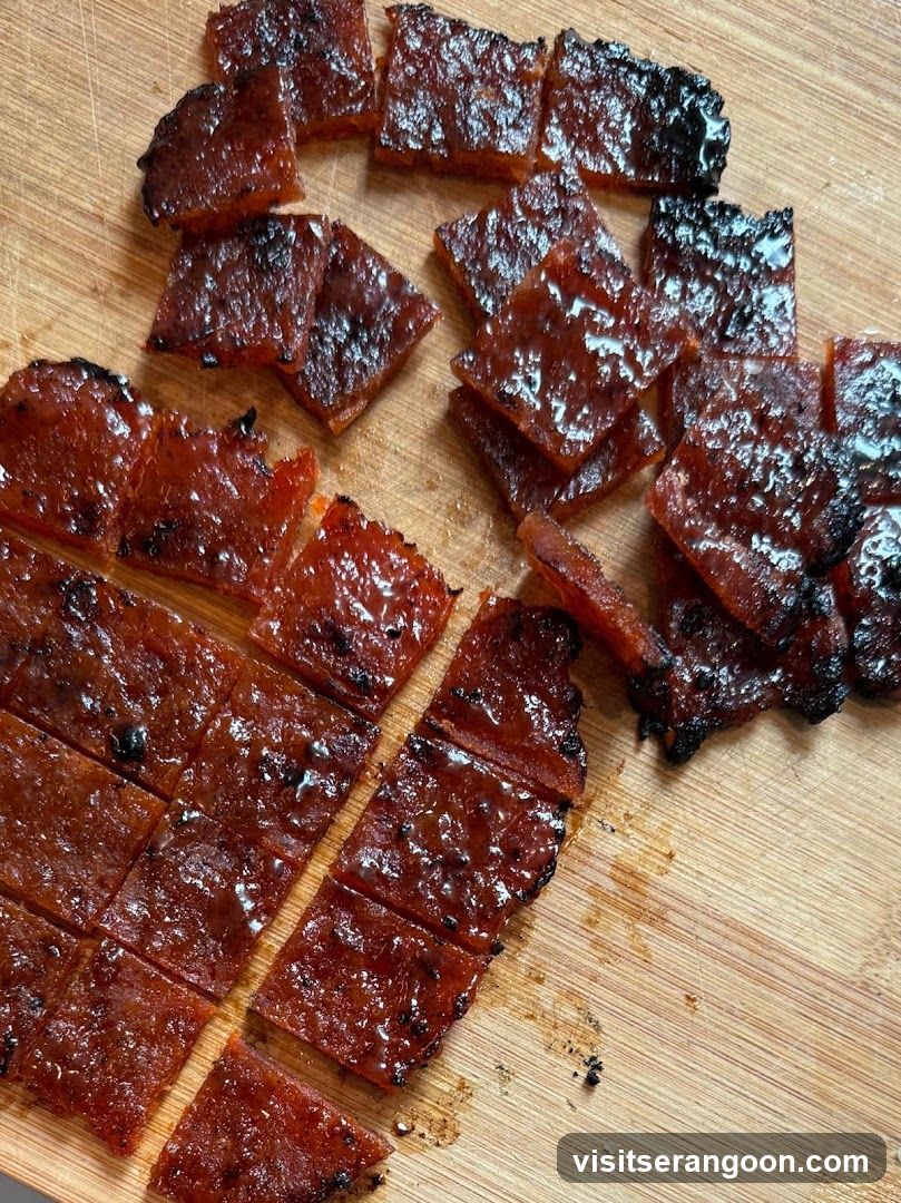 Cut pieces of glazed meat on wooden board
